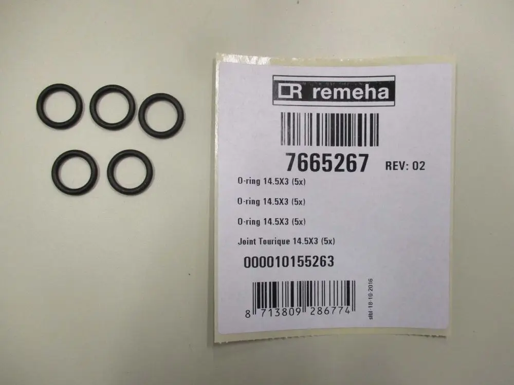 Fünf schwarze O-Ringe auf einer weißen Arbeitsfläche, daneben ein Etikett von Remeha mit Artikel- und Barcode-Informationen.